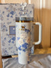 Floral-patterned Stanley mug with floral packaging in the background
