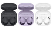 Three pairs of wireless earbuds in open cases on a white background